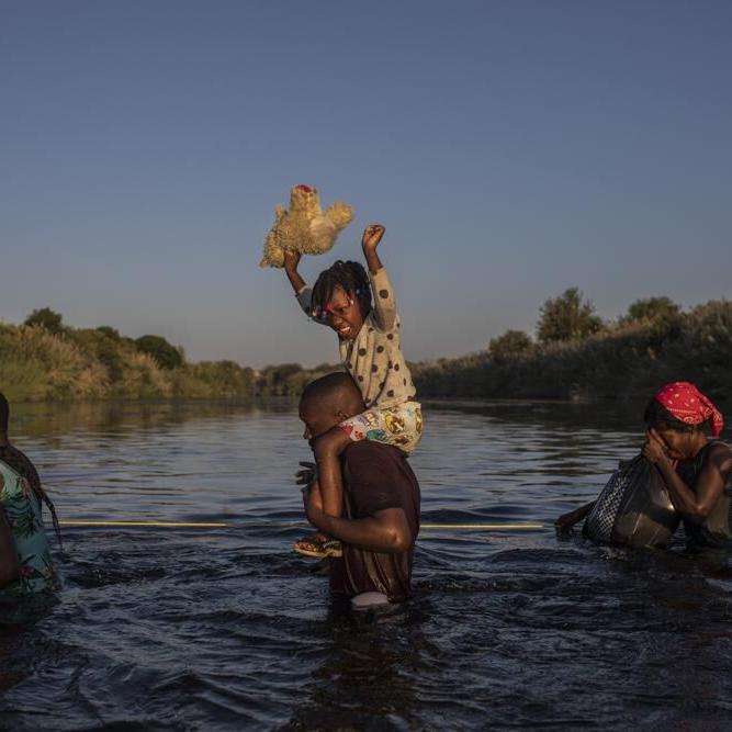 Migrants wade across Rio Grande river